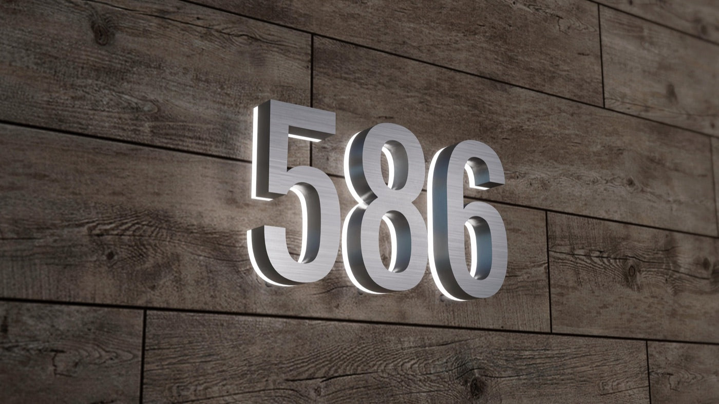 Backlit 586 house numbers mounted on a wood wall